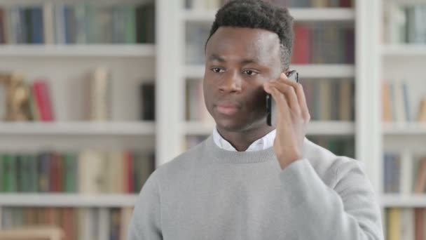 Porträt eines Afrikaners, der auf dem Smartphone spricht — Stockvideo
