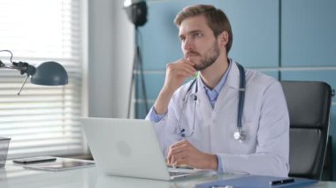 Klinikte Laptop üzerinde çalışırken Doktor Düşünme