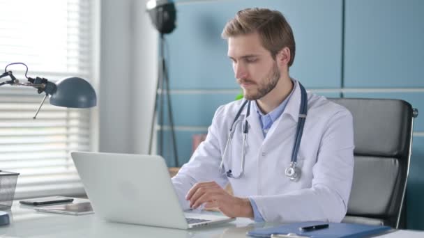 Dokter met laptop glimlachend naar de camera in de kliniek — Stockvideo