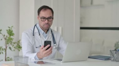 Dizüstü bilgisayarla uğraşırken Orta Çağ Doktoru Smartphone 'da konuşuyor