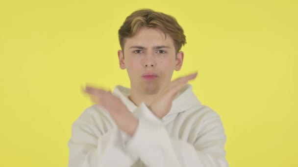 Молодой человек не показывает никаких признаков жеста на жёлтом фоне — стоковое видео
