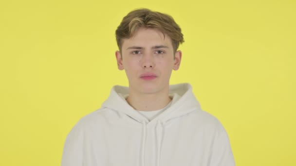 Kciuki w dół Gesture przez młodego człowieka na żółtym tle — Wideo stockowe