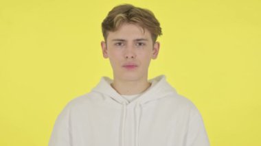 Sarı Arkaplanda Orta Parmak Gösteren Genç Adam 