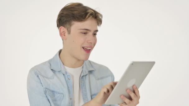 Молодой человек празднует успех на планшете на белом фоне — стоковое видео