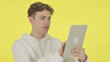 Sarı Arkaplan Tabletinde Başarıyı Kutlayan Genç Adam 