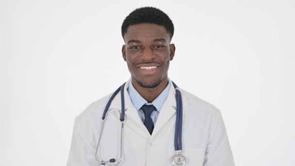Médico africano sonriendo a la cámara sobre fondo blanco — Vídeos de Stock