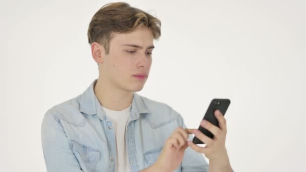 Młody człowiek strata na smartfonie na białym tle — Wideo stockowe