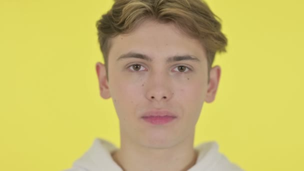 Підсумок усміхненого юнака з жовтого фону — стокове відео