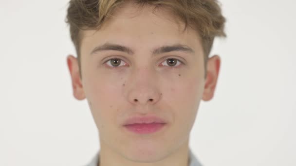 Серйозне обличчя молодої людини на білому тлі — стокове відео