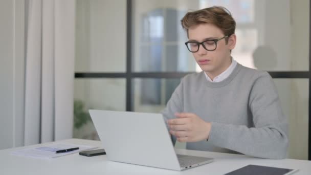 Fiatal férfi, miután írni fájdalom, miközben dolgozik a Laptop a modern irodában — Stock videók