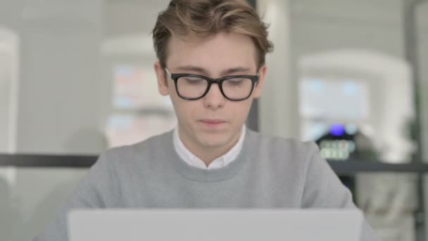 Primer plano del joven que tose mientras trabaja en el ordenador portátil — Vídeo de stock