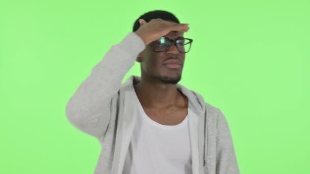 Африканский человек, оглядываясь вокруг, смотрит на зеленый экран — стоковое видео