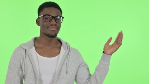 Африканский человек показывает продукт в руке на зеленом фоне — стоковое видео