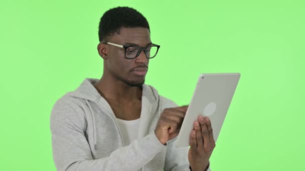 Hombre africano usando tableta digital sobre fondo verde — Vídeo de stock