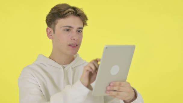 Young Man using Digital Tablet on Yellow Background — Stock Video