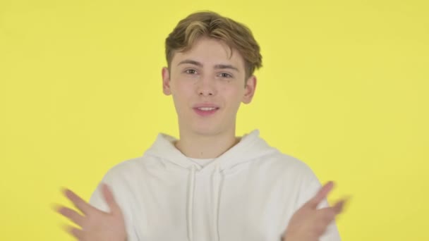 Junger Mann spricht über Online-Videochat auf gelbem Hintergrund — Stockvideo
