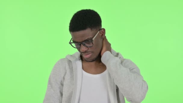 Африканский человек, испытывающий боль в шее на зеленом фоне — стоковое видео
