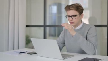Modern Ofiste dizüstü bilgisayarla uğraşırken Genç Adam 'ın başı ağrıyor.