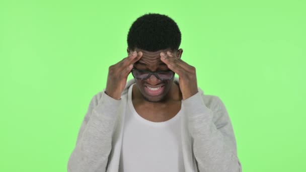 Hombre africano con dolor de cabeza sobre fondo verde — Vídeo de stock