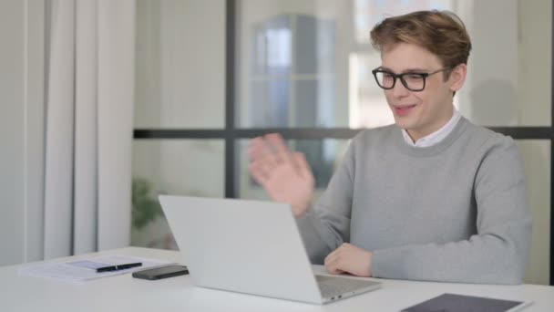 Ung man talar på Video Chaton Laptop i moderna kontoret — Stockvideo