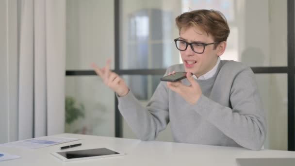 Dühös ember beszél telefonon a modern irodában — Stock videók