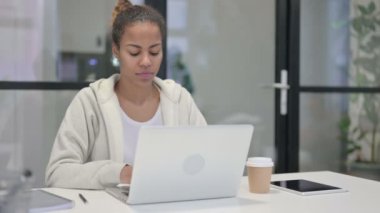 Ofiste dizüstü bilgisayar kullanırken Afrikalı Kadın Kamerayı Gösteriyor
