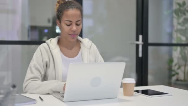 Африканская женщина смотрит в камеру, пользуясь топом в офисе — стоковое видео