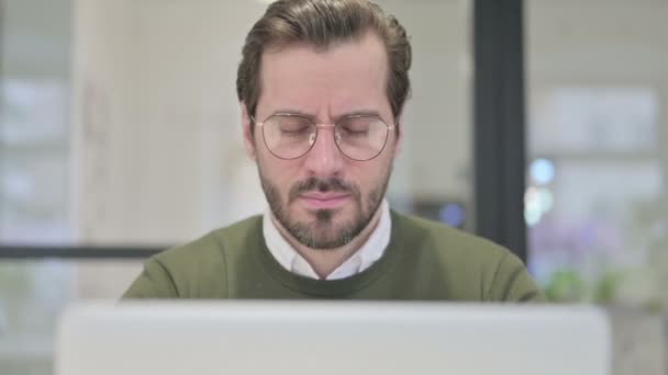 Nahaufnahme eines jungen Geschäftsmannes, der Kopfschmerzen hat, während er Laptop benutzt — Stockvideo