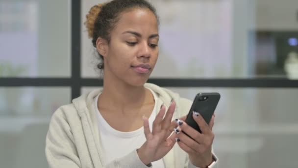 Portret afrykańskiej kobiety reagującej na utratę na smartfonie — Wideo stockowe