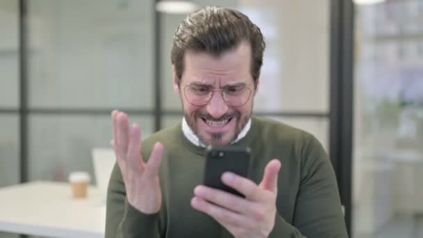 Retrato de Jovem Empresário Reagindo à Perda no Smartphone — Vídeo de Stock