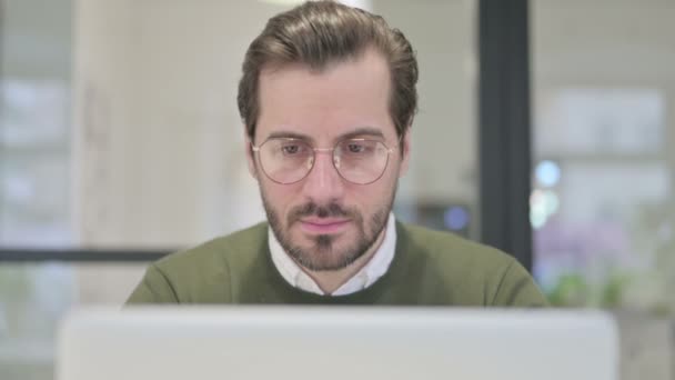 Primer plano de joven hombre de negocios con ordenador portátil mirando en la cámara — Vídeos de Stock