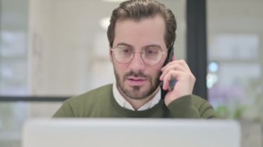 Dizüstü bilgisayarlı Genç İşadamının Akıllı Telefonla Konuşmasını Kapat