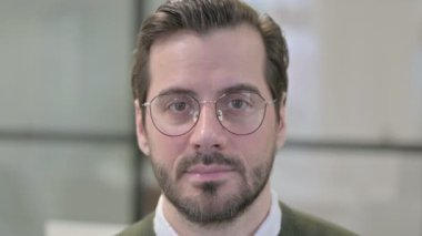 Kameraya gülümseyen genç iş adamının yüzüne yakın çekim