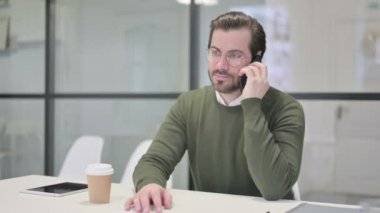 Genç İşadamı Ofiste Akıllı Telefonla Konuşuyor 