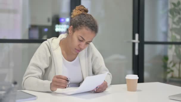 Αφρικανική γυναίκα Ανάγνωση Αναφορές ενώ κάθεται στο γραφείο — Αρχείο Βίντεο
