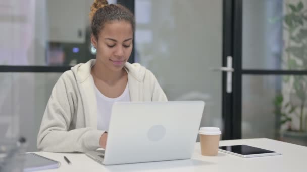 Африканская женщина показывает большой палец вниз знак при использовании ноутбука в офисе — стоковое видео