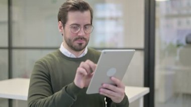 Ofiste tablet kullanan genç iş adamının portresi 