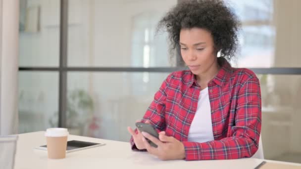 Африканська жінка реагує на втрати на смартфоні — стокове відео