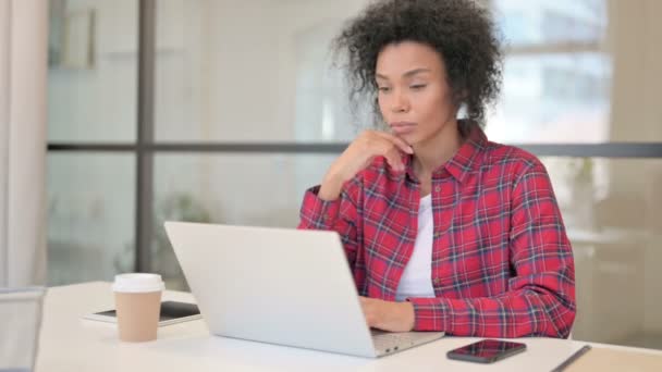 Африканська жінка думає під час роботи на ноутбуці — стокове відео