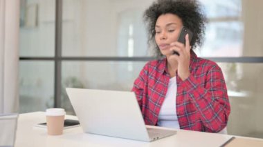 Laptop kullanırken telefonda konuşan Afrikalı Kadın 