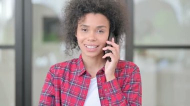 Afrikalı kadın telefonda konuşuyor.