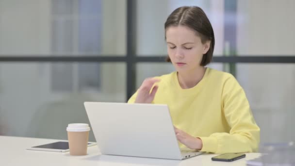 Ung kvinna med nacksmärta när du använder laptop i Office — Stockvideo