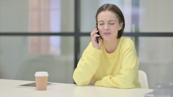 Mujer joven hablando en Smartphone en la oficina — Vídeos de Stock