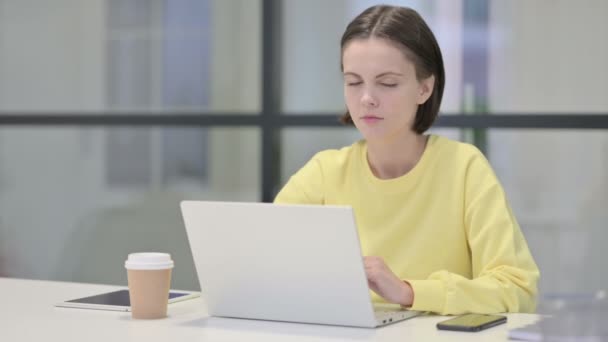 Jonge vrouw toont duimen naar beneden ondertekenen tijdens het gebruik van laptop in Office — Stockvideo