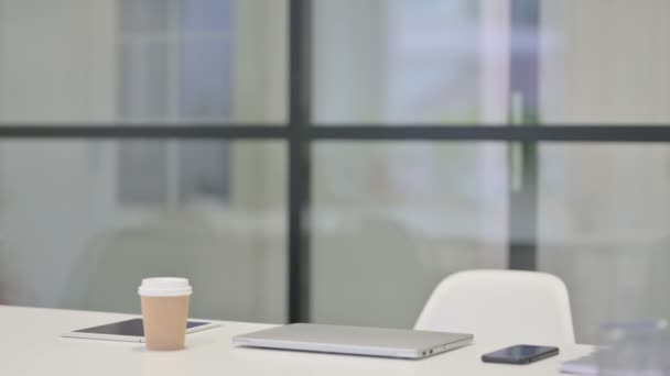 Junge Frau kommt zurück und öffnet Laptop im Büro — Stockvideo