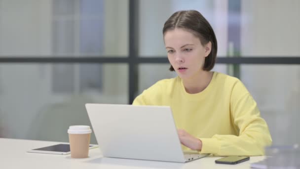 Mujer joven reaccionando a la pérdida mientras usa el ordenador portátil — Vídeos de Stock