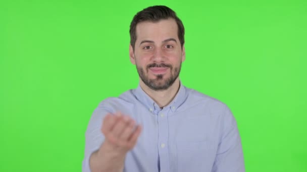 Portret van een man die naar de camera wijst en uitnodigt, groen scherm — Stockvideo