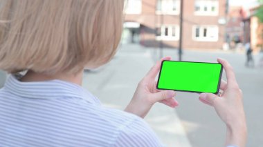 Yeşil Krom Ekran ile Akıllı Telefon İzleyen Kadın