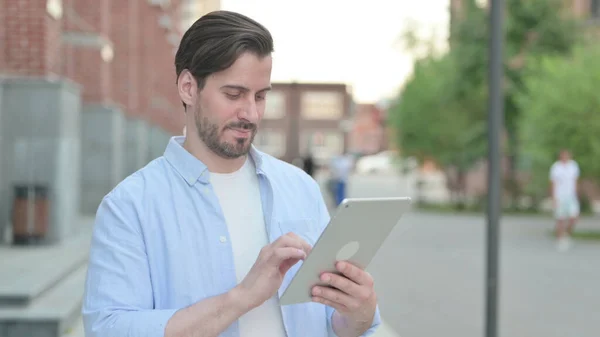 Man Browing Internet na tabletu při stání venku — Stock fotografie