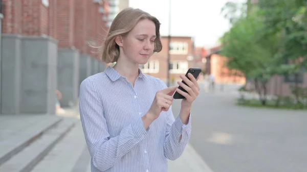 Woman using Smartphone while Standing on the Street — Stockfoto
